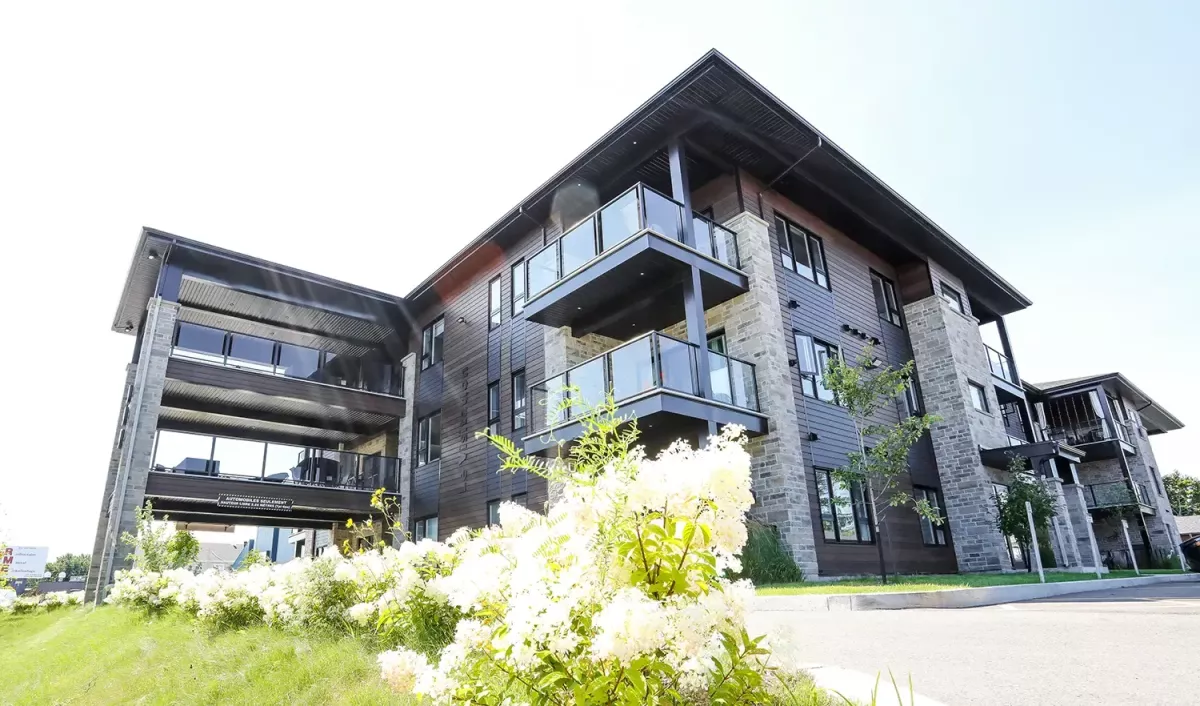 Vue en angle avec structure d'acier décorative et hydrangées – immeuble 24 unités St-Charles-Borromée Lanaudière