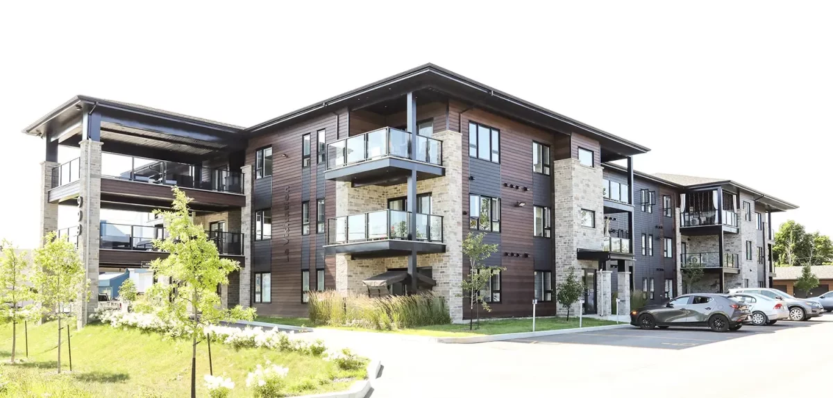 Façade avec balcons vitrés et revêtement brun foncé – immeuble locatif 24 unités St-Charles-Borromée Lanaudière par BGC