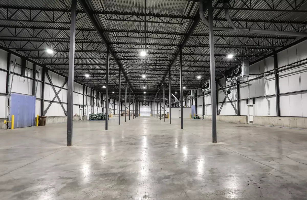 Vaste entrepôt avec colonnes d'acier et plancher de béton poli – construction agricole par Gestion BGC