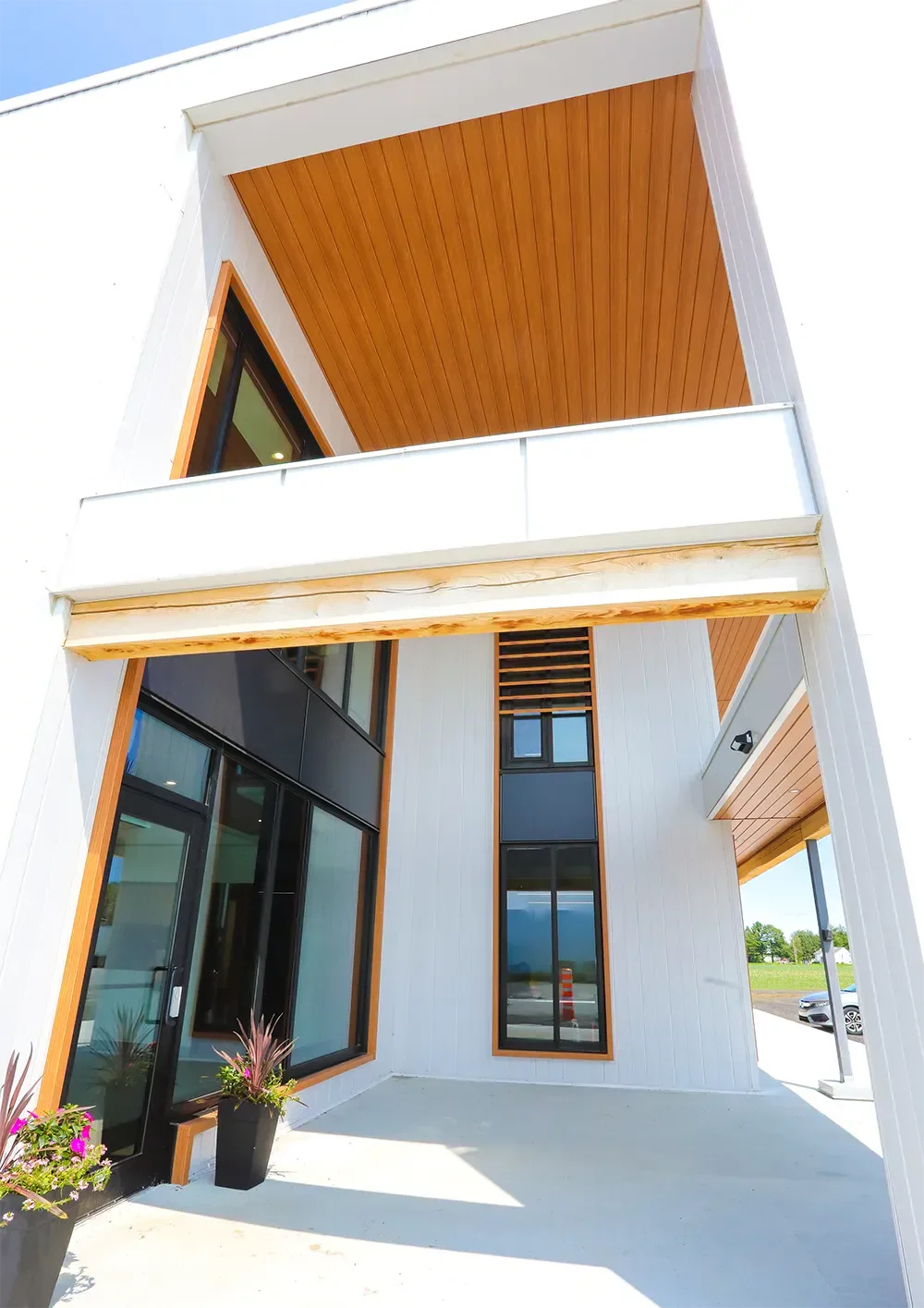 Entrée principale avec marquise en bois et revêtement d'acier blanc – bâtiment agricole moderne Saint-Thomas