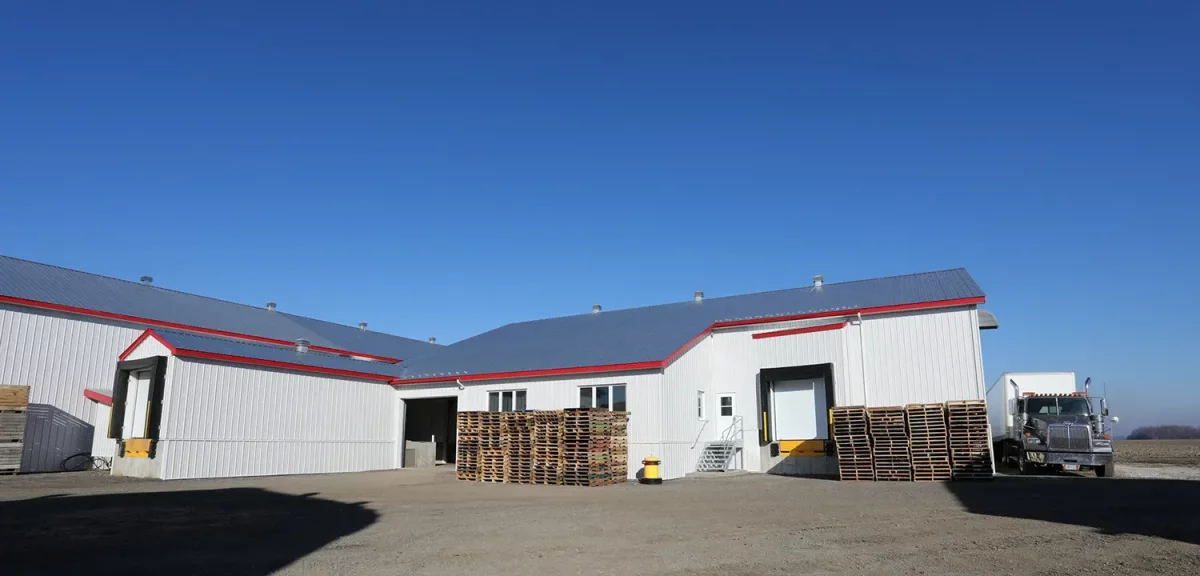 Vue extérieure des bâtiments agricoles blancs à toiture grise – Ferme Jobin & Roberge Saint-Alexis Lanaudière par BGC