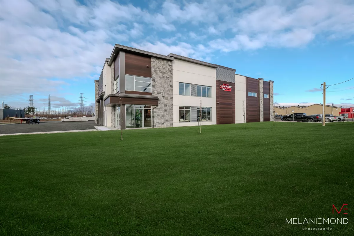Façade du bâtiment administratif avec revêtement de pierre et bois – projet commercial Épandage YFL Joliette par BGC