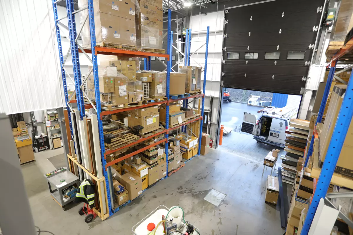 Intérieur d'entrepôt avec rayonnages, chariot élévateur et quai de chargement – projet Bessette par Gestion BGC