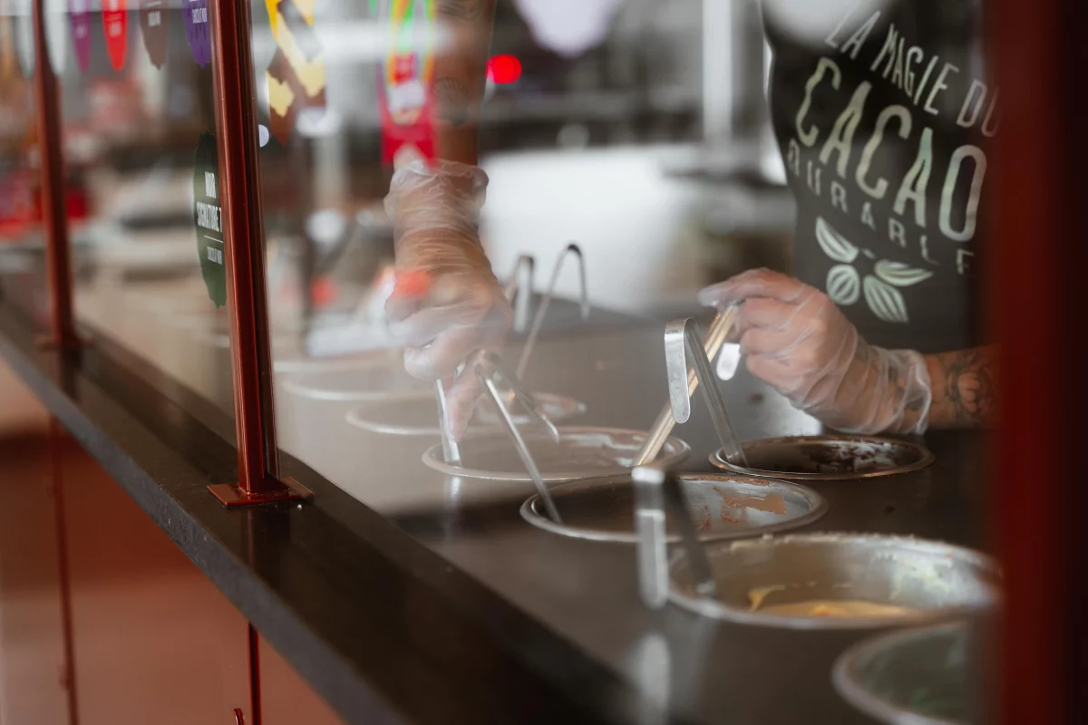 Employé préparant du chocolat au comptoir – Chocolats Favoris Joliette