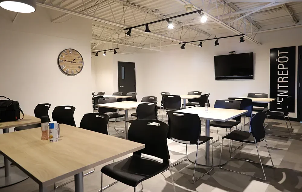 Cafétéria avec plafond en structure d'acier apparente, tables et éclairage sur rail – Équipements Industriel Joliette