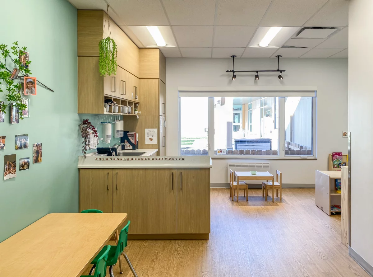 Local de garderie avec mur vert, comptoir de service et grandes fenêtres