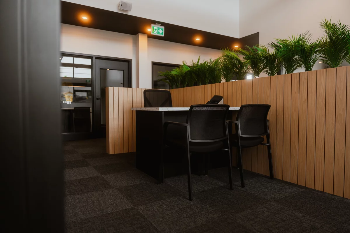 Postes de travail avec cloisons en lattes de bois et plantes intégrées