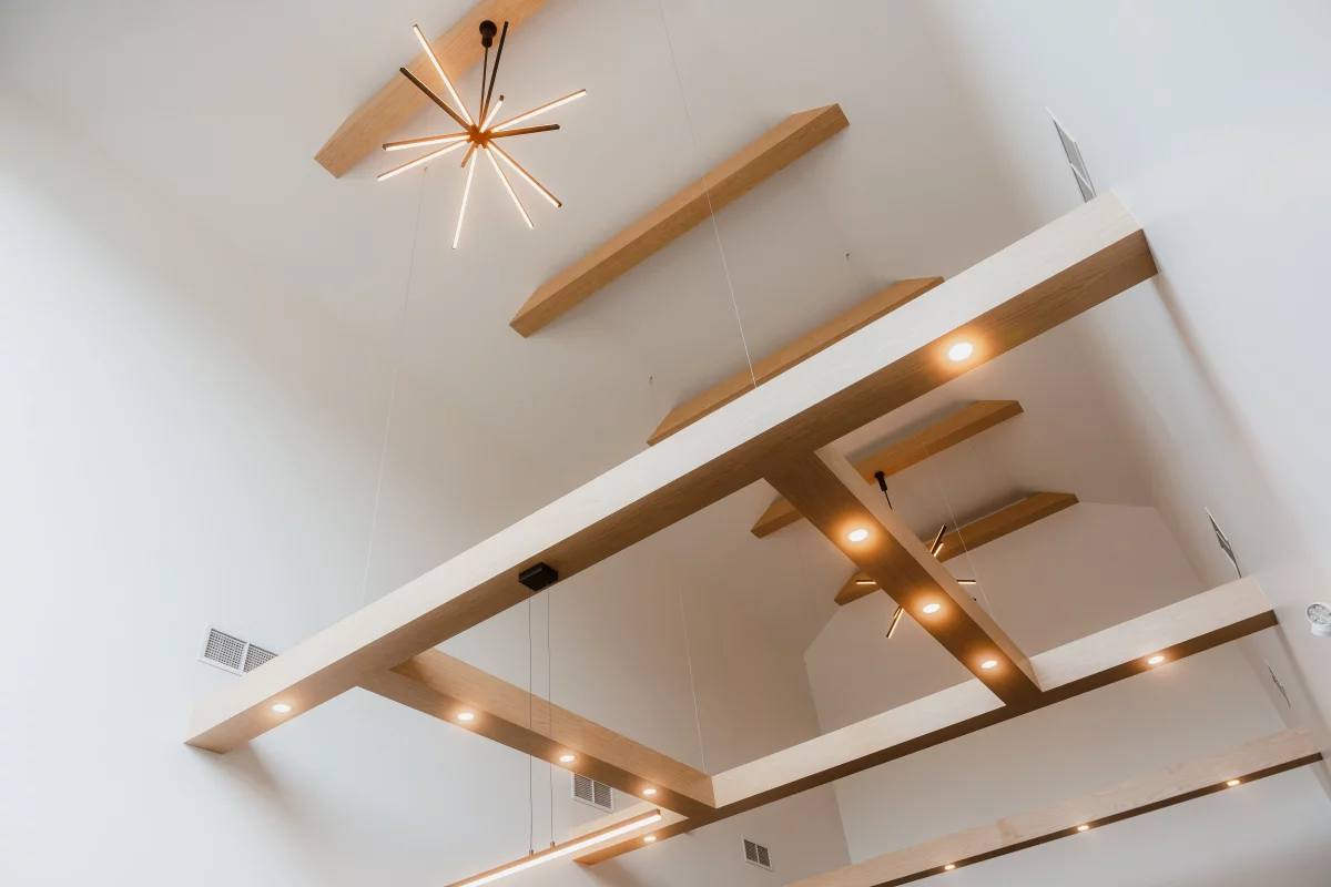 Plafond à double hauteur avec poutres de bois décoratives et luminaire étoile