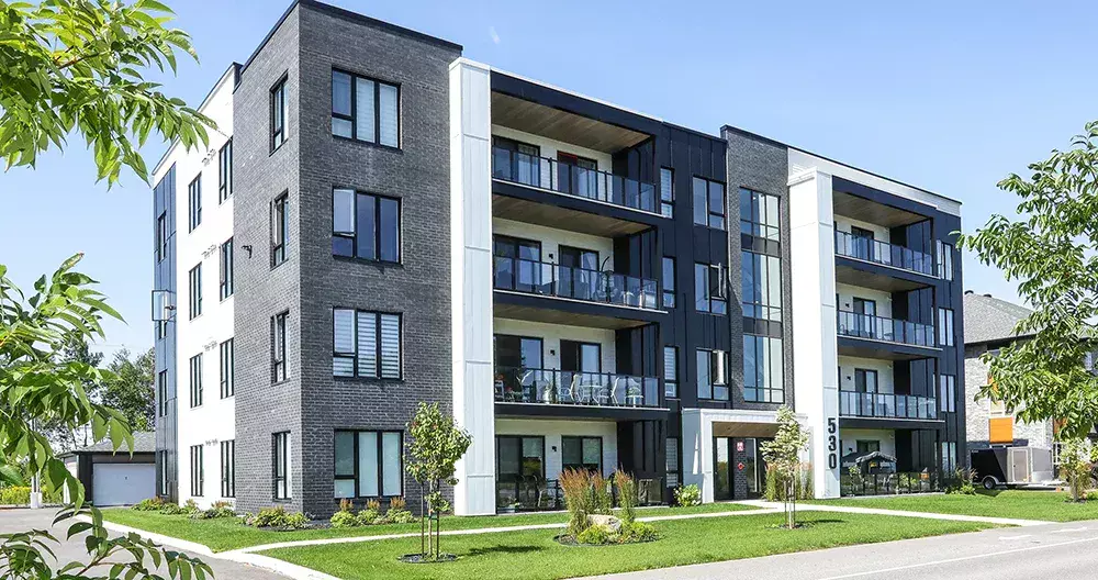 Façade complète de l'immeuble 16 unités Munger avec revêtement contemporain noir et gris – projet résidentiel BGC